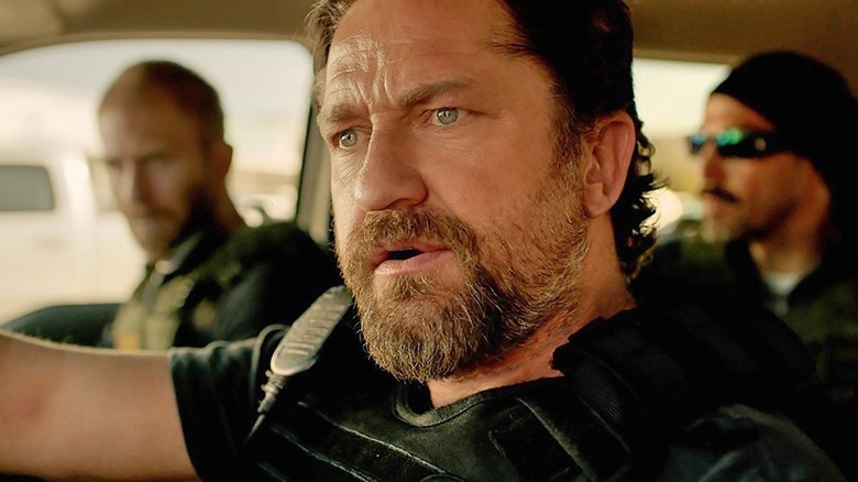 Gerard Butler behind the wheel of a cop car as Big Nick O'Brien in Den of Thieves