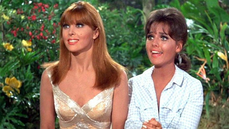 Ginger and Mary Ann, seated at a table, smiling.