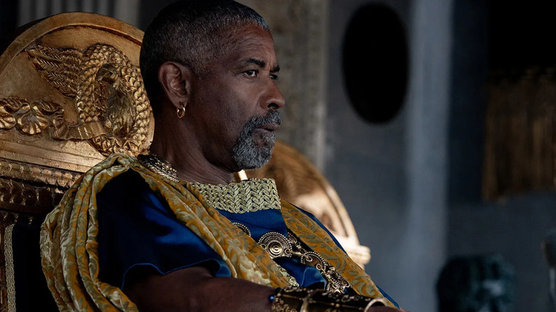 Macrinus (Denzel Washington) sentado em um trono assistindo a luta em Gladiador II