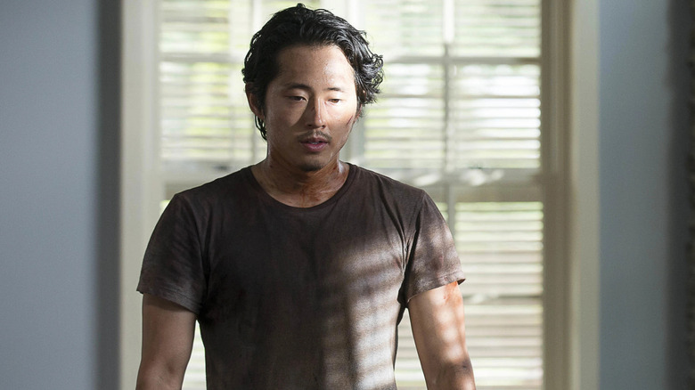 Steven Yeun as Glenn standing in quiet solitude in the Walking Dead episode No Way Out