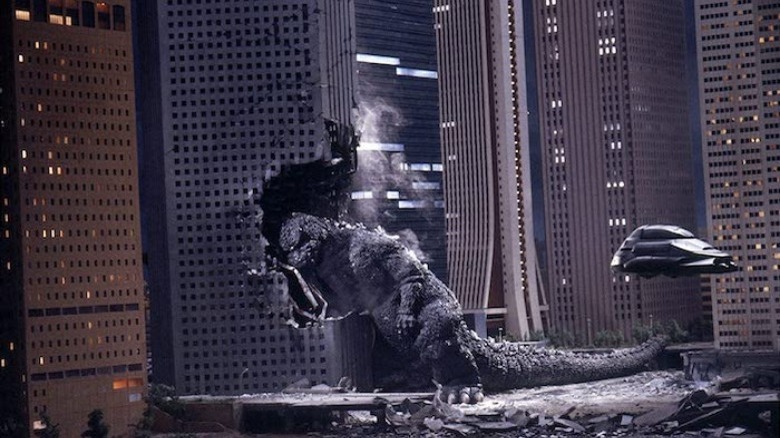 Godzilla falling into a building