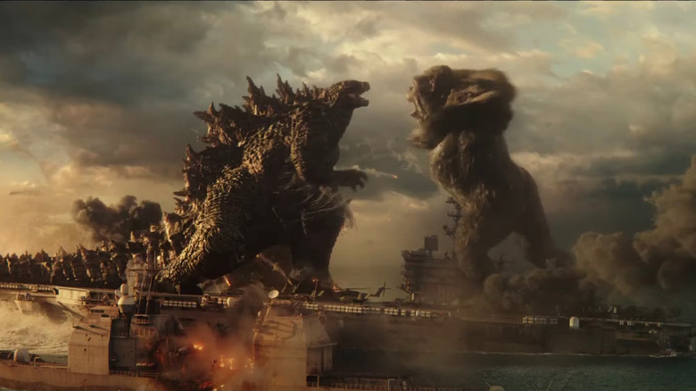 Godzilla and Kong roar at each other on burning ships in Godzilla vs. Kong