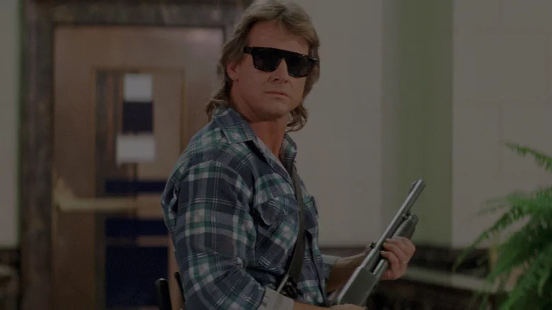 Roddy Piper with sunglasses and shotgun in They Live