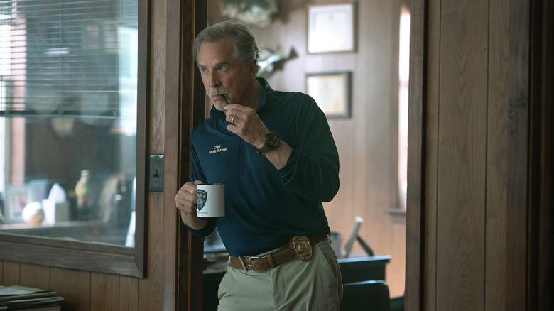 Chief Sandy in doorway drinking coffee, Rebel Ridge