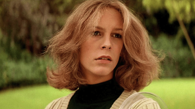 Jamie Lee Curtis as Laurie Strode looks down the street in Halloween 1978