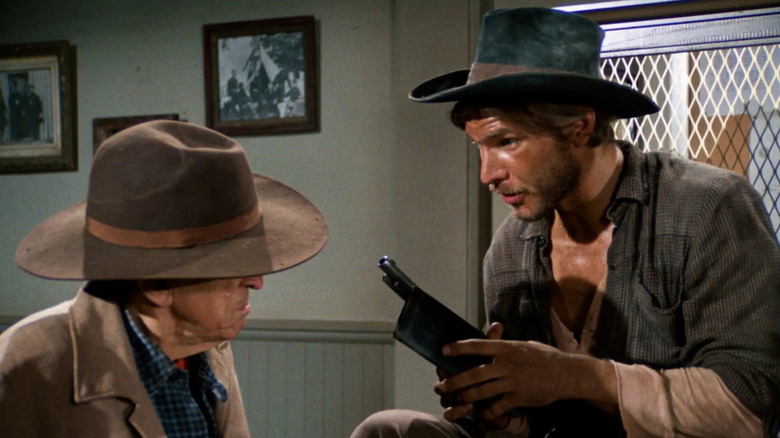 Harrison Ford como Hobey segurando uma arma no Gunsmoke