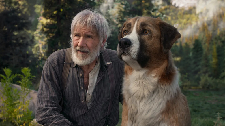 Harrison Ford sebagai John dan Buck duduk bersama di hutan belantara di The Call of the Wild