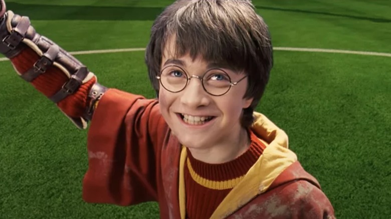 Daniel Radcliffe's Harry Potter smiles on the Quidditch field in Harry Potter and the Sorcerer's Stone