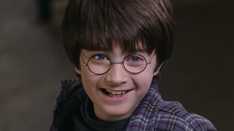 Daniel Radcliffe sorrindo como Harry Potter em Harry Potter e a pedra do feiticeiro