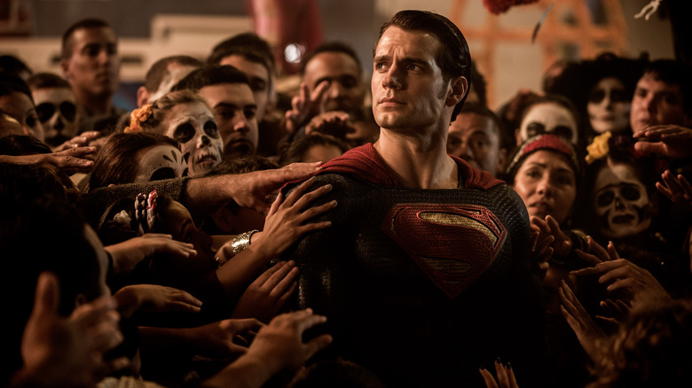 Henry Cavill as Superman surrounded by a crowd of people in the film 