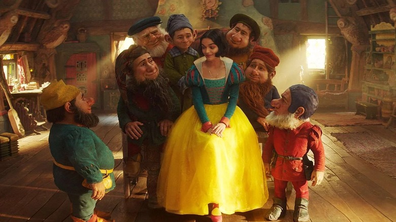 Rachel Zegler as Snow White surrounded by the seven dwarfs in Snow White (2025)