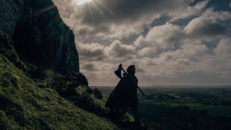 Gawain carries axe across landscape