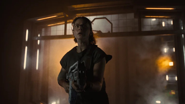 Woman holding large gun in spaceship in Alien: Romulus