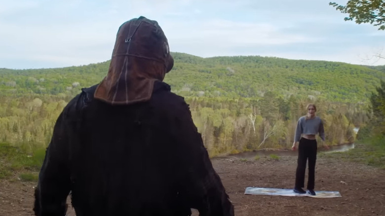 Masked man walking towards woman in In a Violent Nature