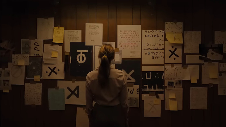 Woman standing in front of wall of evidence in Longlegs