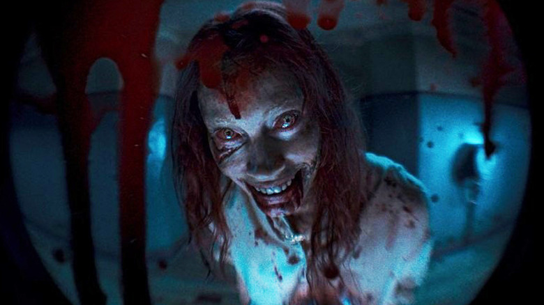 Evil Dead Rise bloody woman smiling