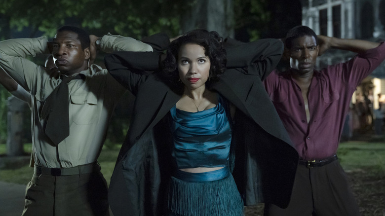 Jonathan Majors, Jurnee Smollett, and another man with their hands on their heads in Lovecraft Country