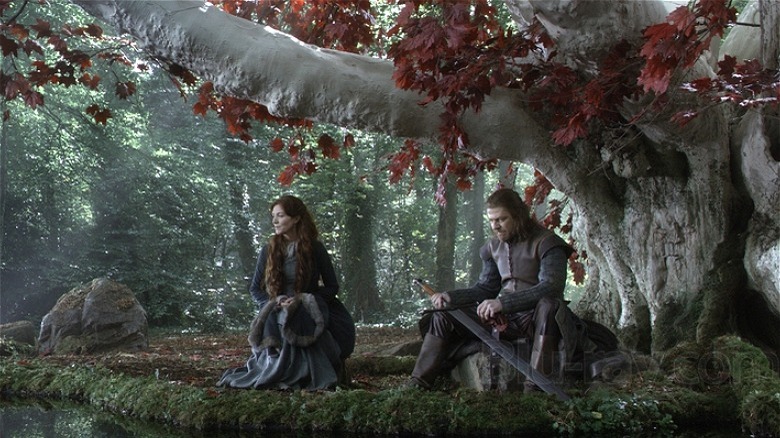 Ned and Catelyn Stark infront of the tree symbolizing The Old Gods