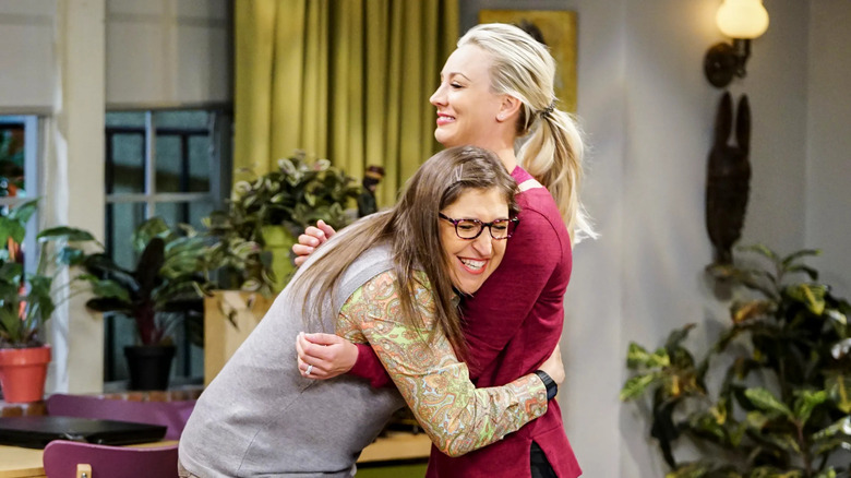 Amy hugging Penny while they smile on The Big Bang Theory