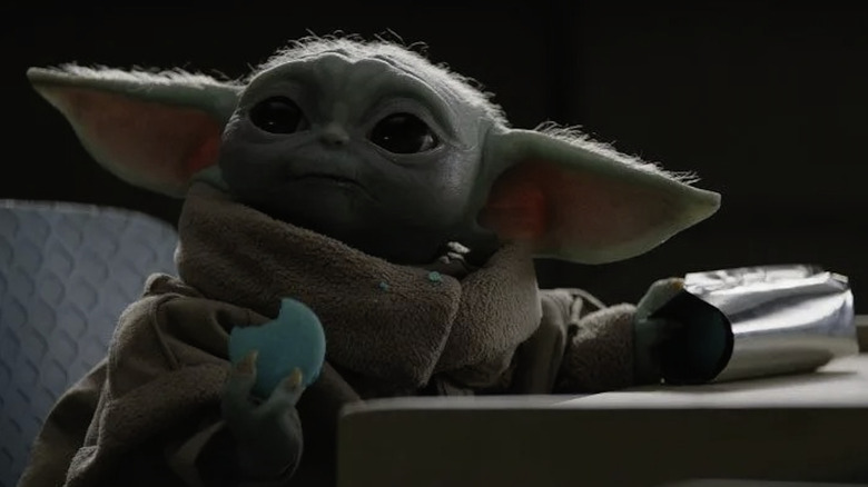 Grogu puppet holding blue macaron in The Mandalorian