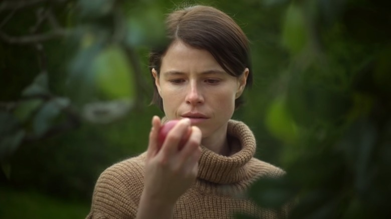 Harper in Men looks at an apple