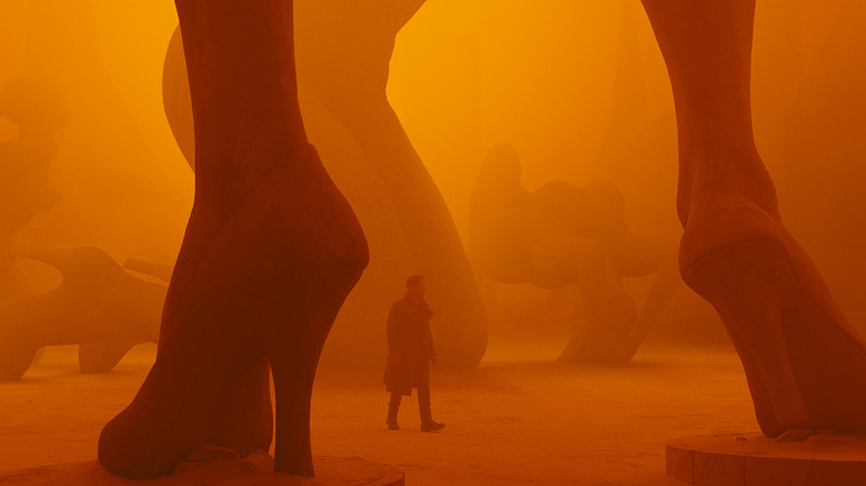 Ryan Gosling walking through the orange ruins of Las Vegas in Blade Runner 2049 