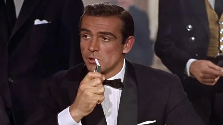 Sean Connery's James Bond lights a cigarette in Dr No