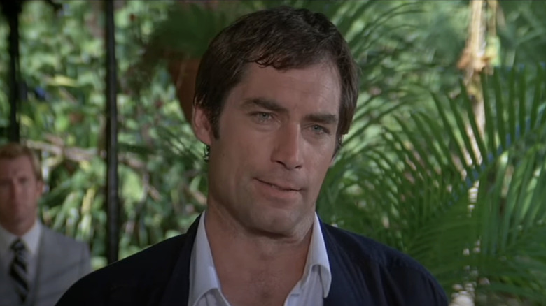 Timothy Dalton's James Bond stands against a background of green shrubery in Licence to Kill