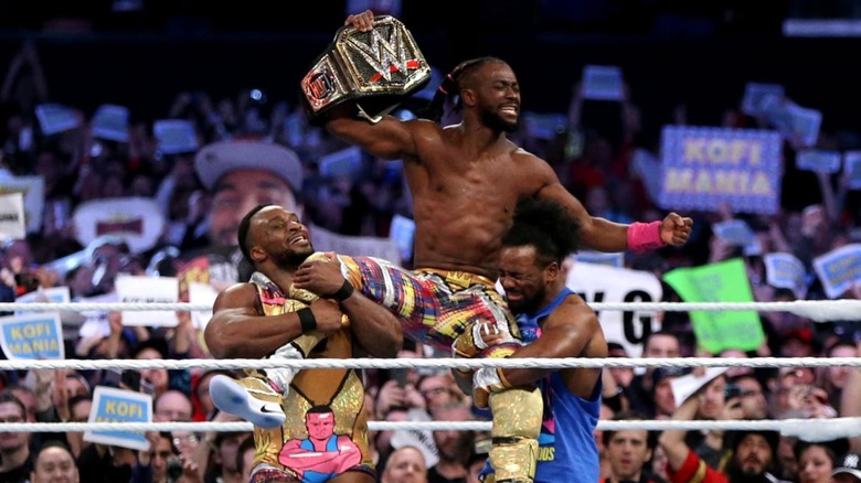 Kofi Kingston being held up by The New Day at Wrestlemania 35