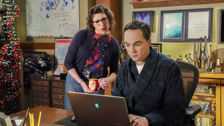 Amy y Sheldon miran la computadora del joven Sheldon.