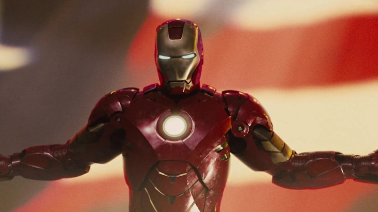 Iron Man spreading his arms in front of a projected American flag in Iron Man 2