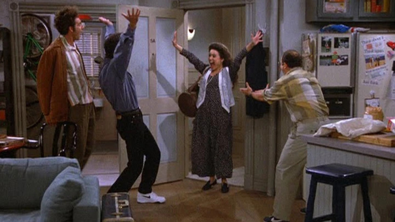 Michael Richards as Kramer, Jerry Seinfeld as Jerry, Julia Louis-Dreyfus as Elaine, and Jason Alexander as George cheering each other on Seinfeld