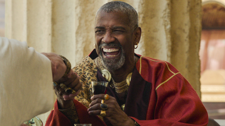 Denzel Washington como Macrinus, fazendo um acordo tomando café em Gladiador II