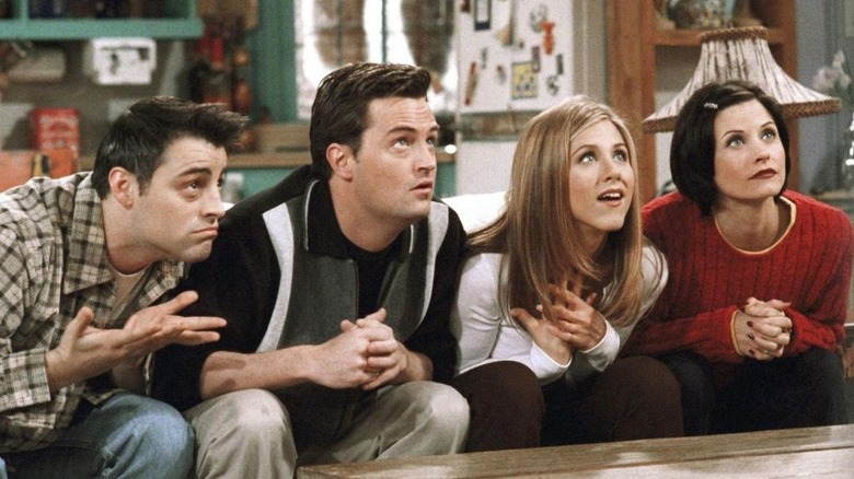 Chandler Bing interpretado por Matthew Perry y otros se sientan y miran expectantes a los amigos.