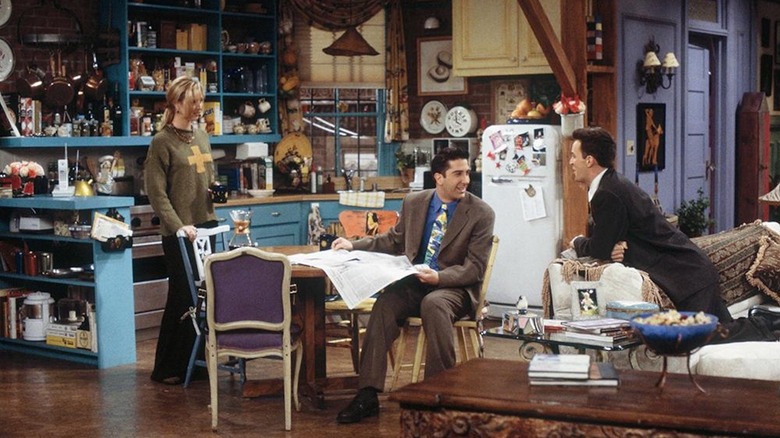 Lisa Kudrow sebagai Phoebe, David Schwimmer sebagai Ross dan Matthew Perry sebagai Chandler nongkrong di apartemen Monica di Friends