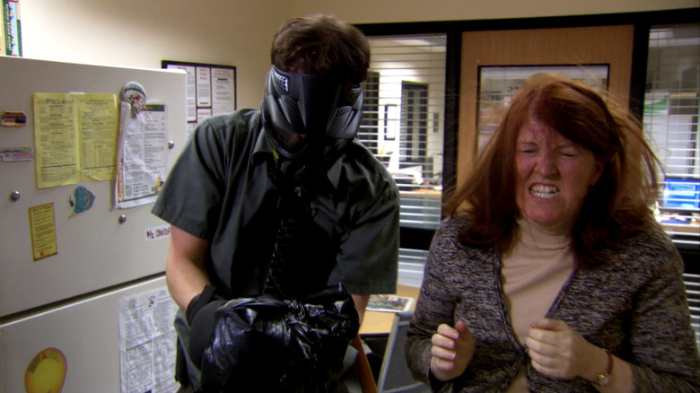 O Dwight Shrite de Rainn Wilson fica ao lado de Meredith Palmer, de Kate Flannery, depois de remover um saco de lixo contendo um taco de sua cabeça no escritório