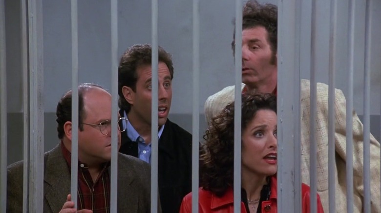 Jerry Seinfeld's Jerry, Julia Louis-Dreyfus's Elaine, Jason Alexander's George, Michael Richards' Kramer stand shocked behind bars in Seinfeld