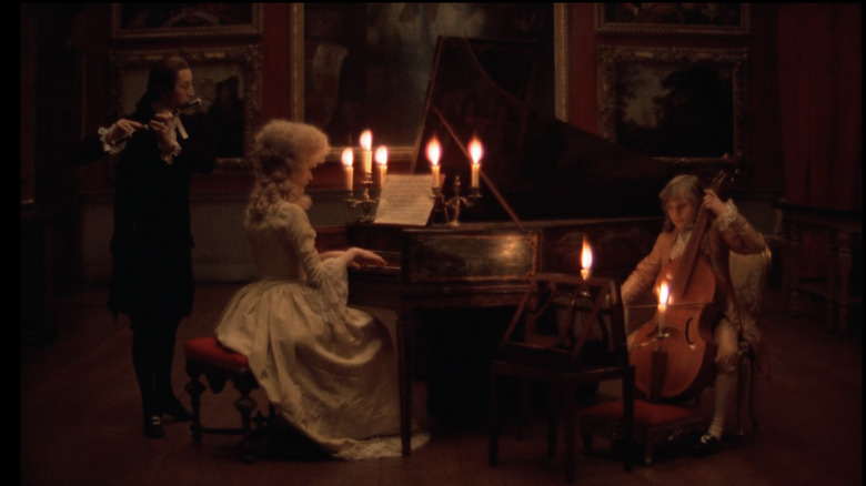 Musicians play amid sparsely lit candles 
