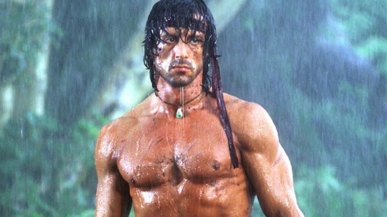 Sylvester Stallone standing in the rain in Rambo: First Blood - Part II