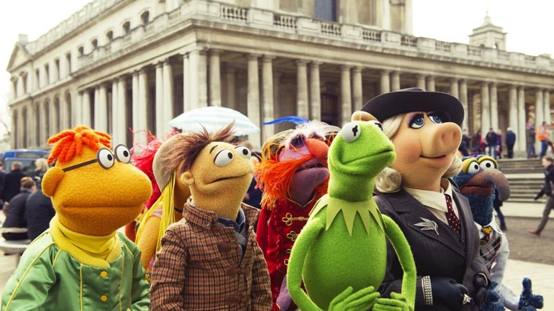 Scooter, Walter, Floyd Pepper, Kermit the Frog, Miss Piggy e Gonzo, o Grande Stand do lado de fora em uma praça européia e veja algo fora da tela à sua esquerda