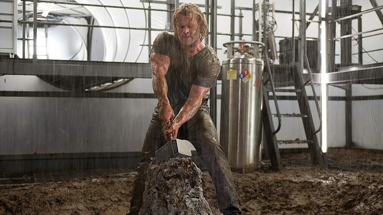 Thor tries to pull Mjolnir out of stone in the rain in Thor