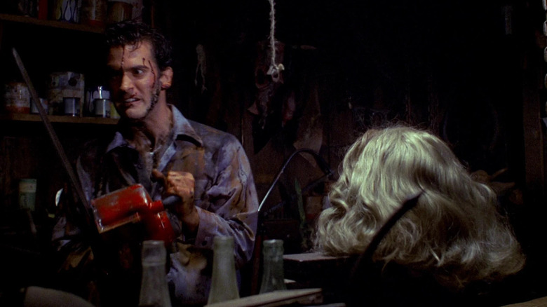 Ash, with a chainsaw, about to cut up his girlfriend's severed head, locked in a vice. A scene from Evil Dead 2: Dead By Dawn.