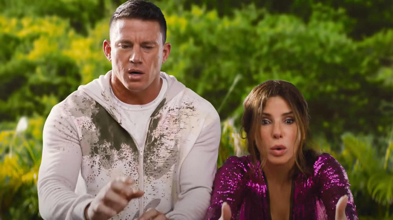 Channing Tatum and Sandra Bullock watching something fall in The Lost City