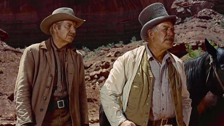 Ward Bond stands in front of Horses in The Searchers