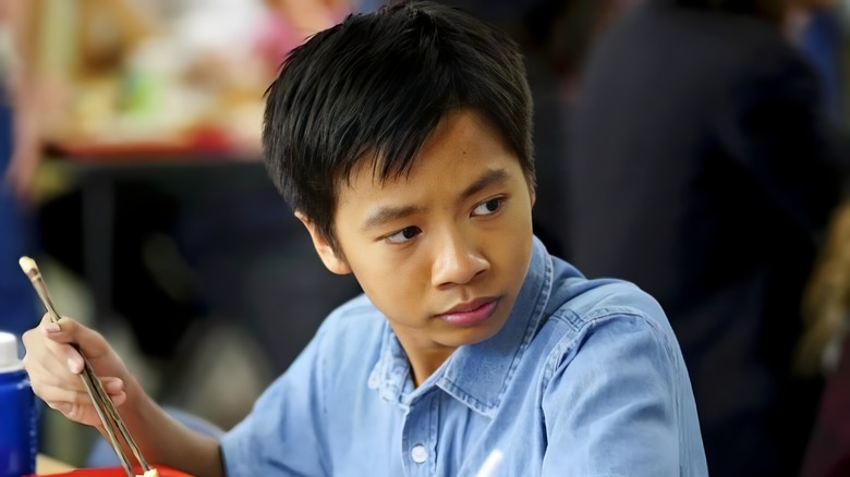 Tam Nguyen holding chopsticks on Young Sheldon