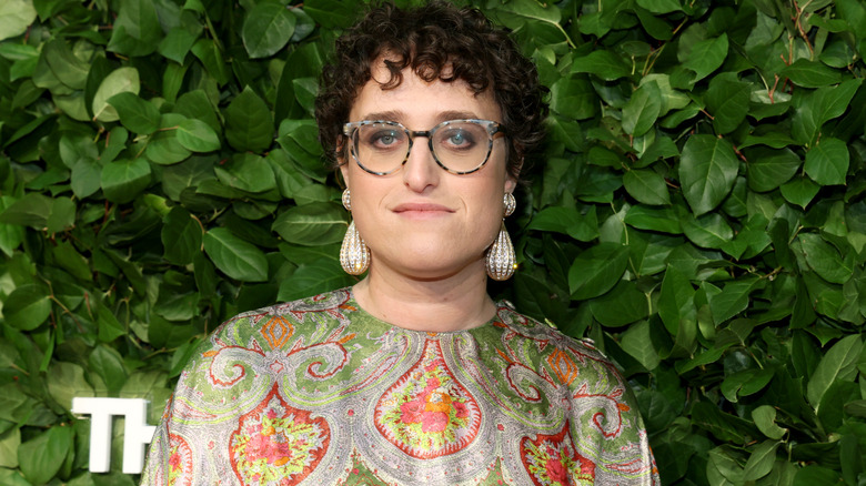 Jane Schoenbrun posing for a photo in front of a green background