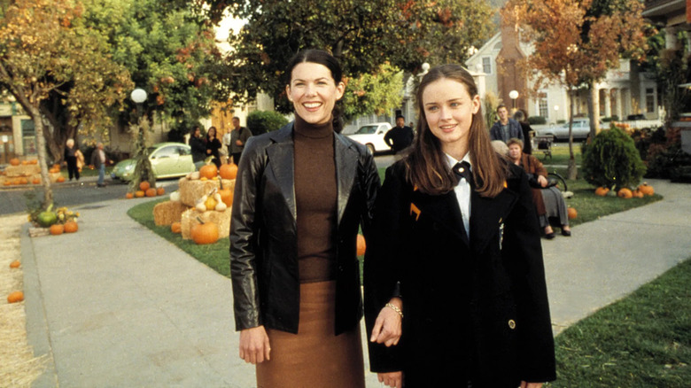 Lauren Graham as Lorelai and Alexis Bledel as Rory Gilmore standing in the town square of Stars Hollow in Gilmore Girls