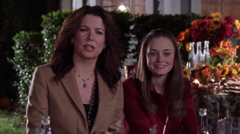 Lauren Graham as Lorelai and Alexis Bledel as Rory Gilmore sitting outside at a reception at night Gilmore Girls