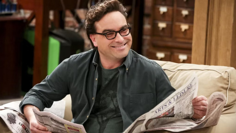 Leonard on The Big Bang Theory, holding a newspaper