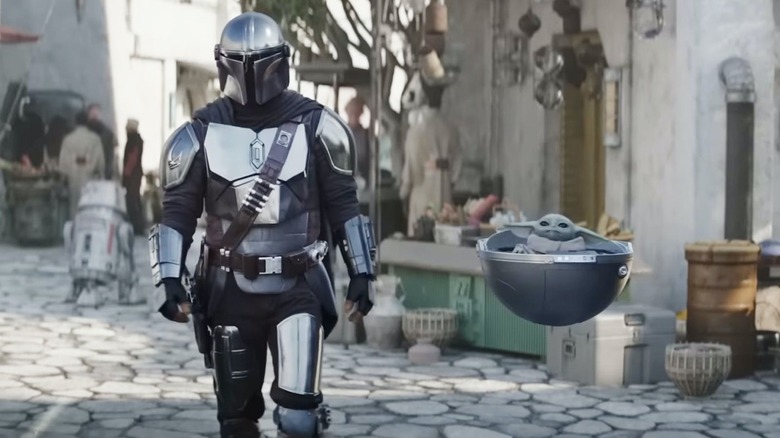 Mando and Grogu walking through the streets in The Mandalorian